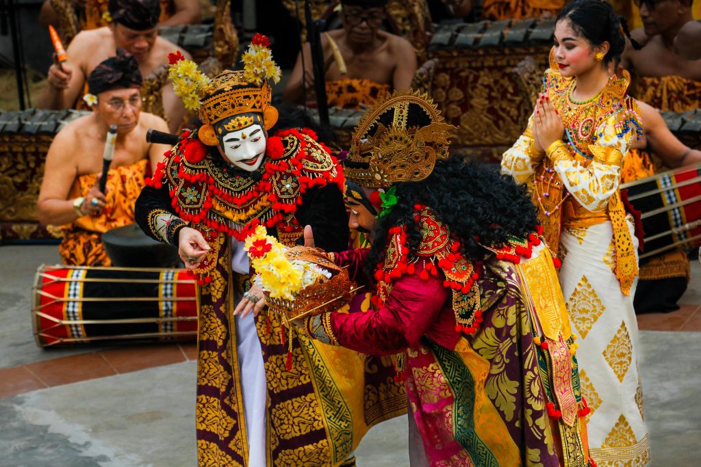 Vibrant Balinese dance with intricate costumes during a cultural ceremony outdoors.